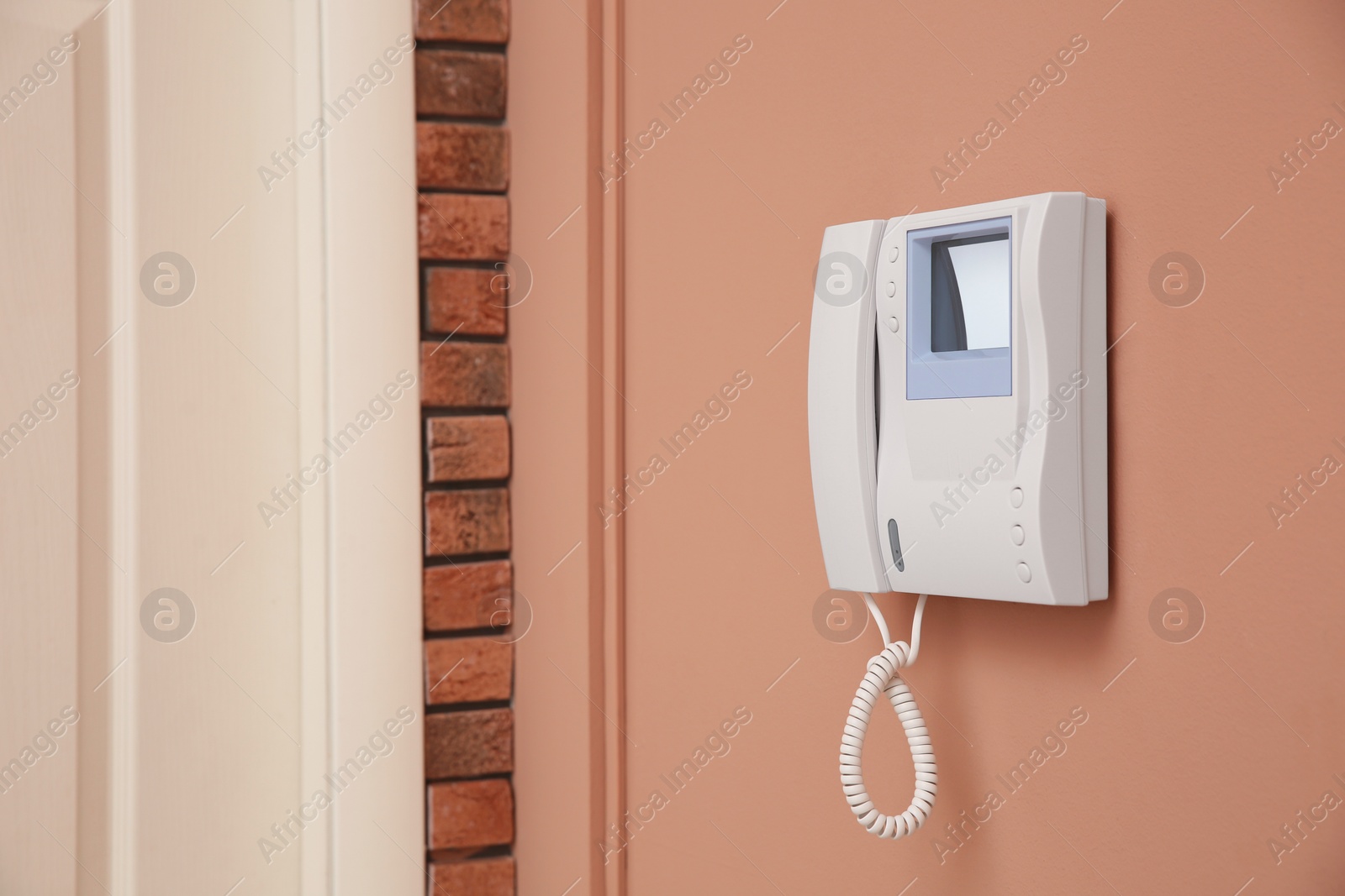 Photo of Modern intercom system with handset on beige wall, space for text