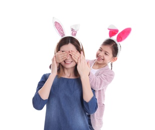 Happy woman and daughter with bunny ears on white background