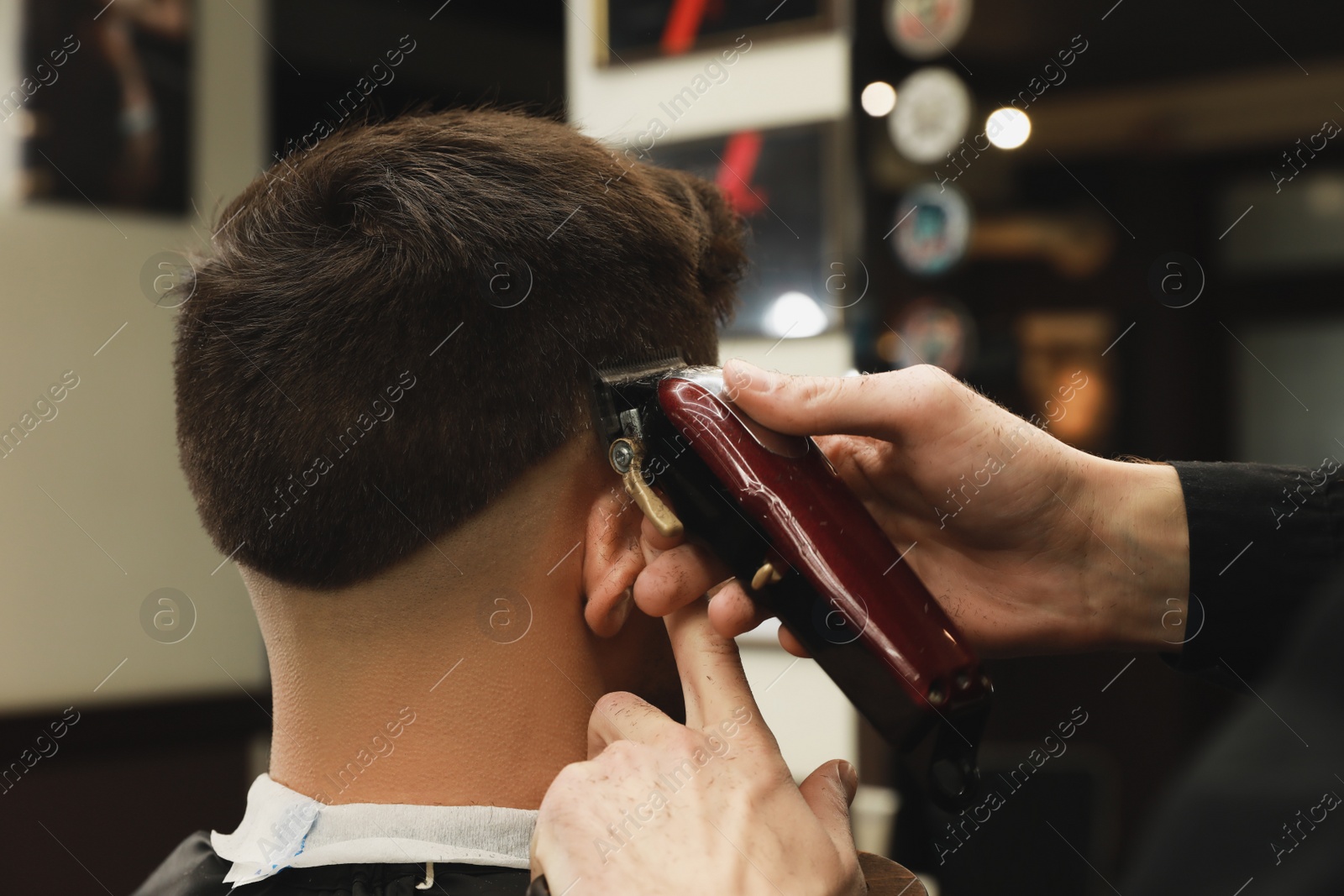 Photo of Professional hairdresser making stylish haircut in salon, back view