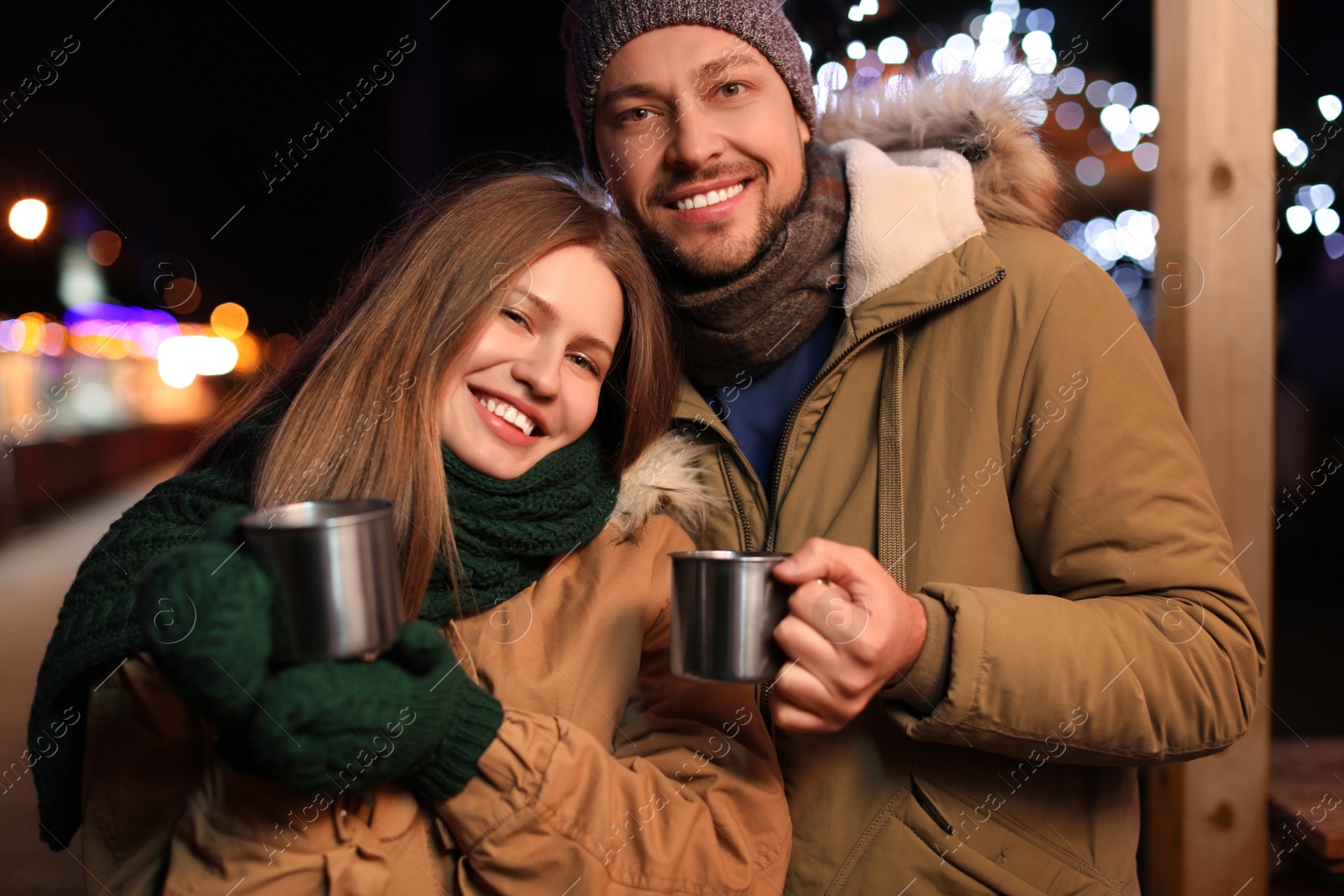 Photo of Happy couple with mulled wine at winter fair