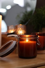 Photo of Lit candles on wooden dressing table indoors