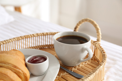 Photo of Tray with tasty breakfast on bed. Cozy morning