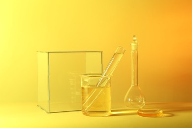 Laboratory analysis. Different glassware on table against yellow background