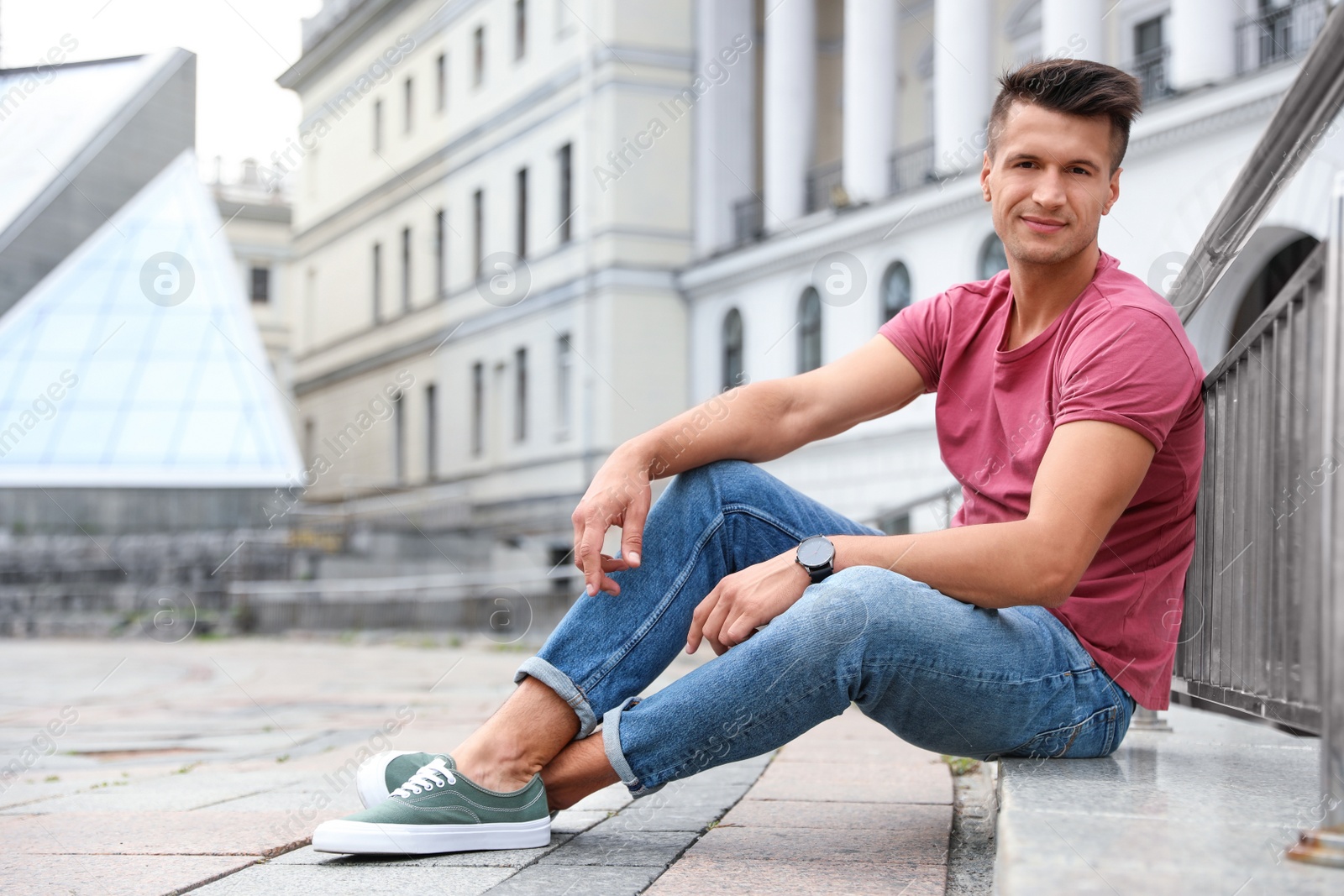 Photo of Portrait of handsome young man on city street. Space for text