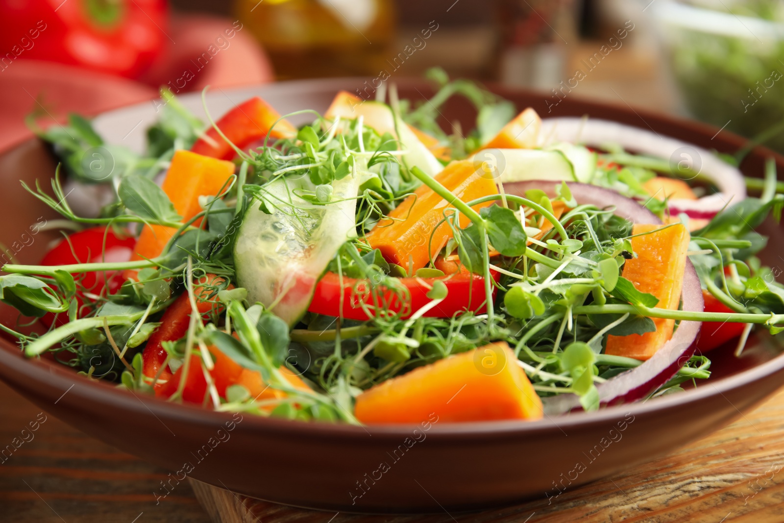 Photo of Delicious vegetable salad with microgreen served on wooden table, closeup