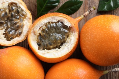 Photo of Delicious ripe granadillas on wooden table, closeup