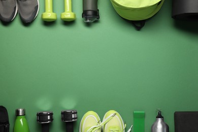 Frame made of different sports equipment on green background, flat lay. Space for text