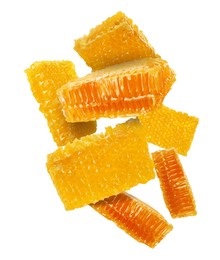 Pieces of honeycomb falling on white background