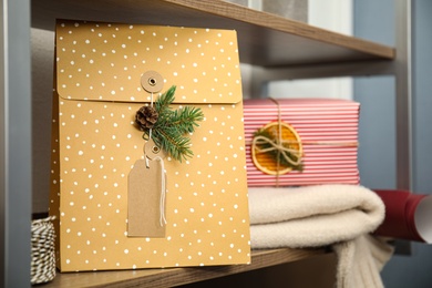 Photo of Beautifully decorated Christmas present on wooden rack, space for text