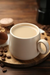 Photo of Cup of coffee and delicious macarons on wooden table, closeup