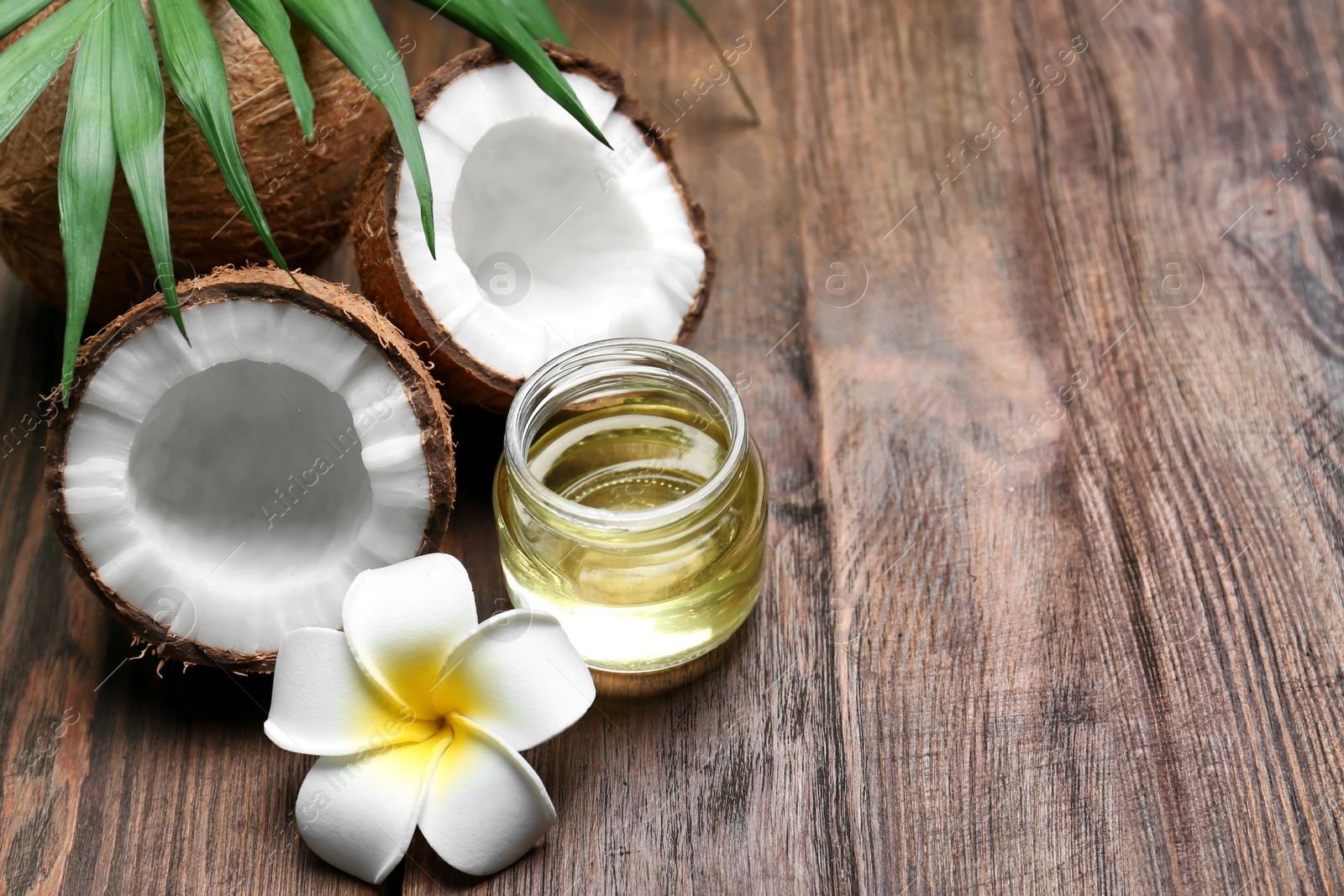 Photo of Beautiful composition with coconut oil and nuts on wooden background