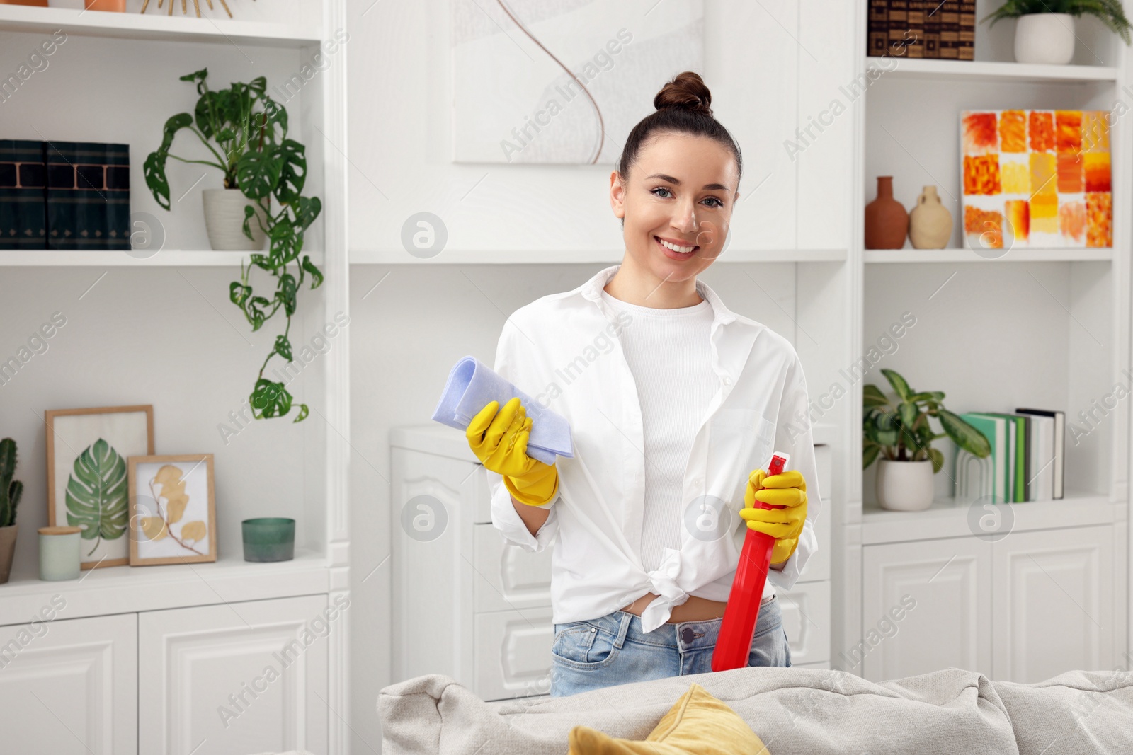 Photo of Spring cleaning. Young woman tidying up room at home