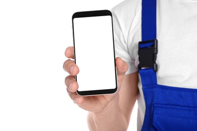 Professional repairman in uniform showing smartphone on white background, closeup