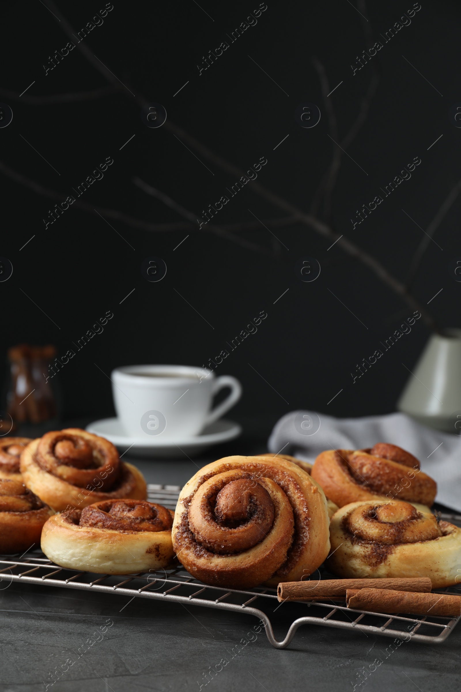 Photo of Tasty cinnamon rolls on black table, space for text