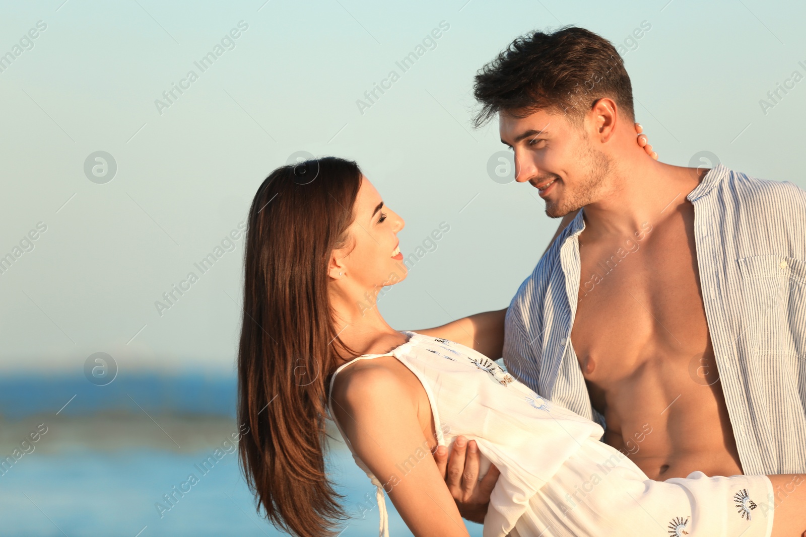 Photo of Happy young couple posing near sea on beach