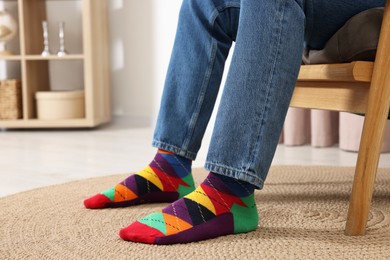 Photo of Man in stylish colorful socks and jeans indoors, closeup