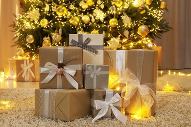 Many gift boxes near decorated Christmas tree at home