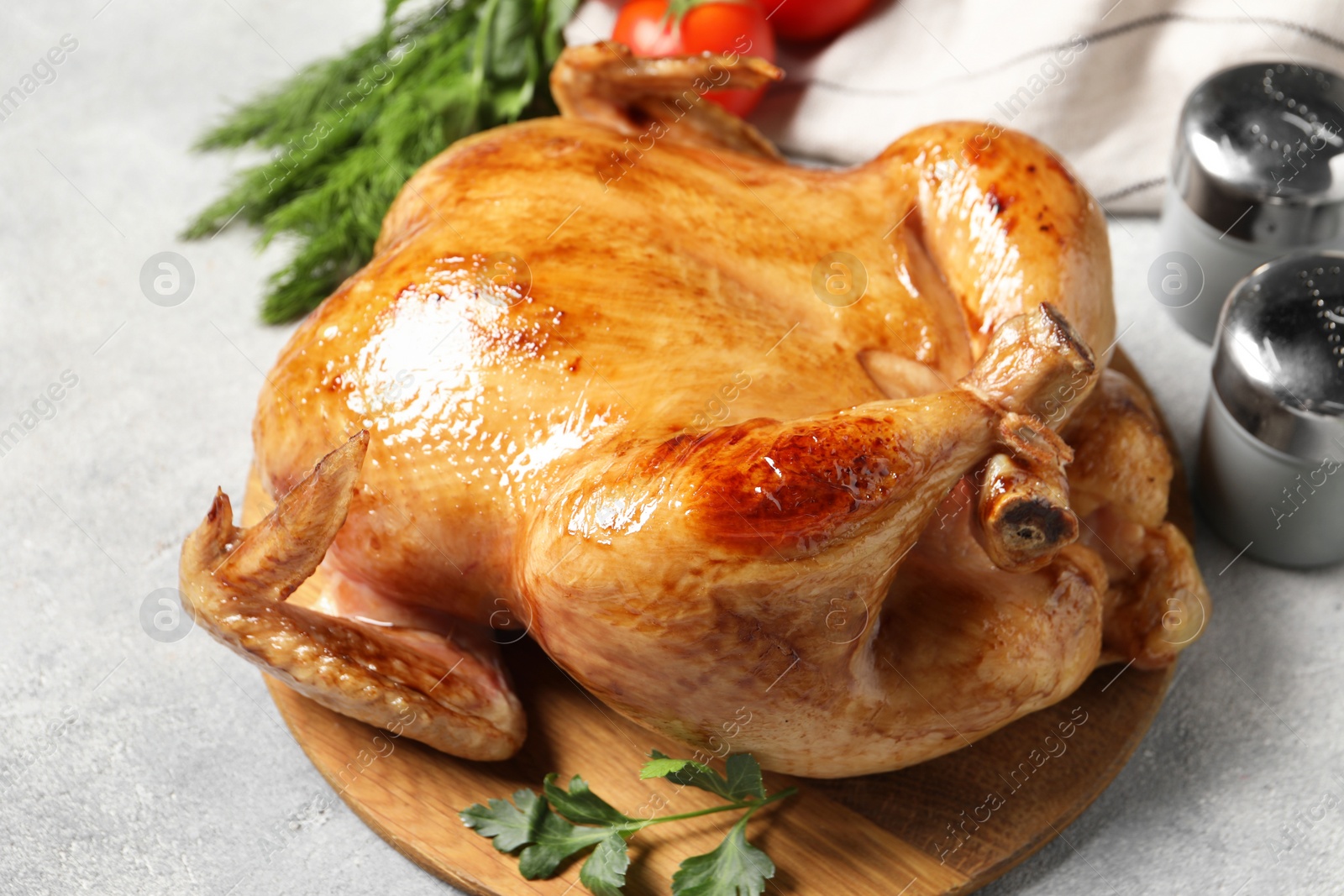 Photo of Tasty roasted chicken with parsley on light grey table