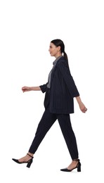 Photo of Young woman in formal suit walking on white background