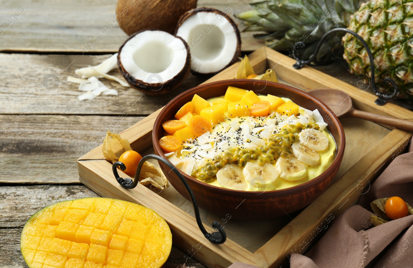 Photo of Tasty smoothie bowl with fresh fruits served on wooden table