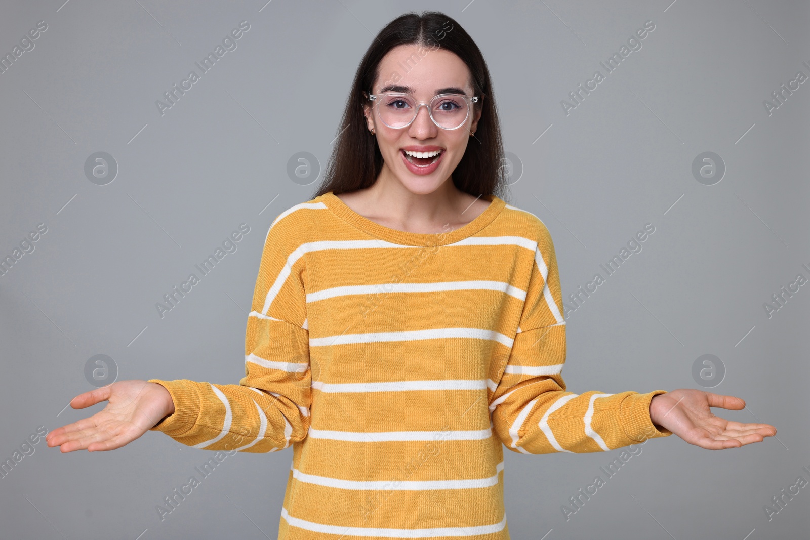 Photo of Portrait of happy surprised woman on grey background