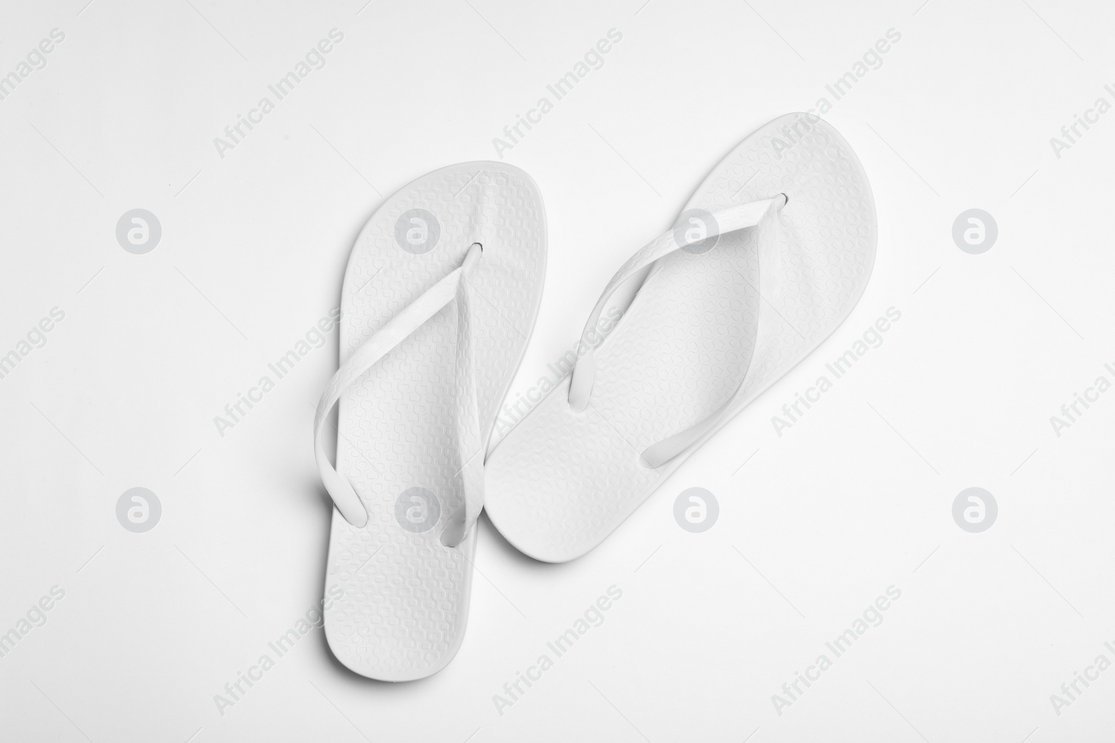 Photo of Pair of flip flops on white background, top view. Beach accessories