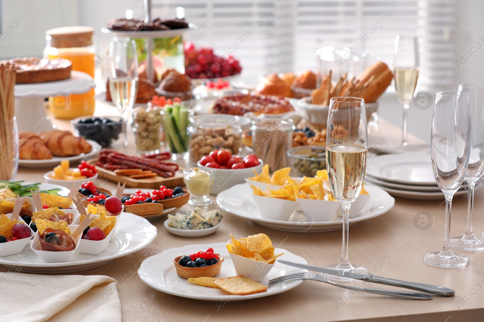 Photo of Variety of snacks on wooden table in buffet style indoors