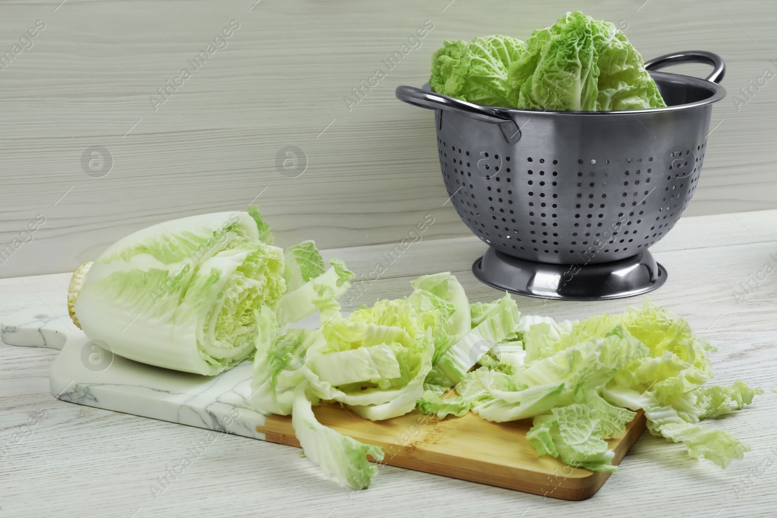 Photo of Chopped Chinese cabbage on white wooden kitchen table