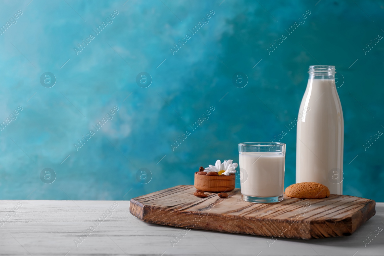 Photo of Composition with milk on table against color background