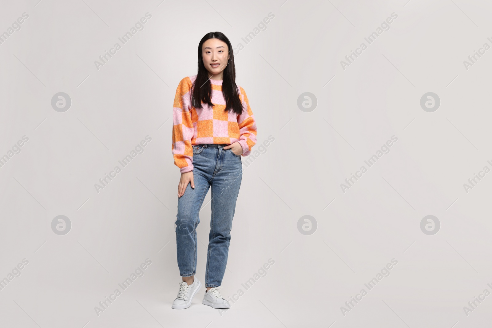 Photo of Full length portrait of smiling woman on light background. Space for text