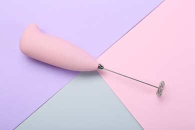 Photo of Pink milk frother wand on color background, top view