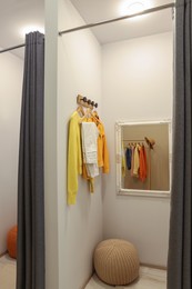 Photo of Dressing room with mirror in fashion store. Stylish design