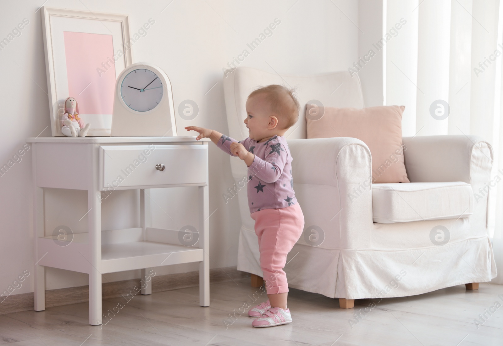 Photo of Cute baby girl walking in room at home