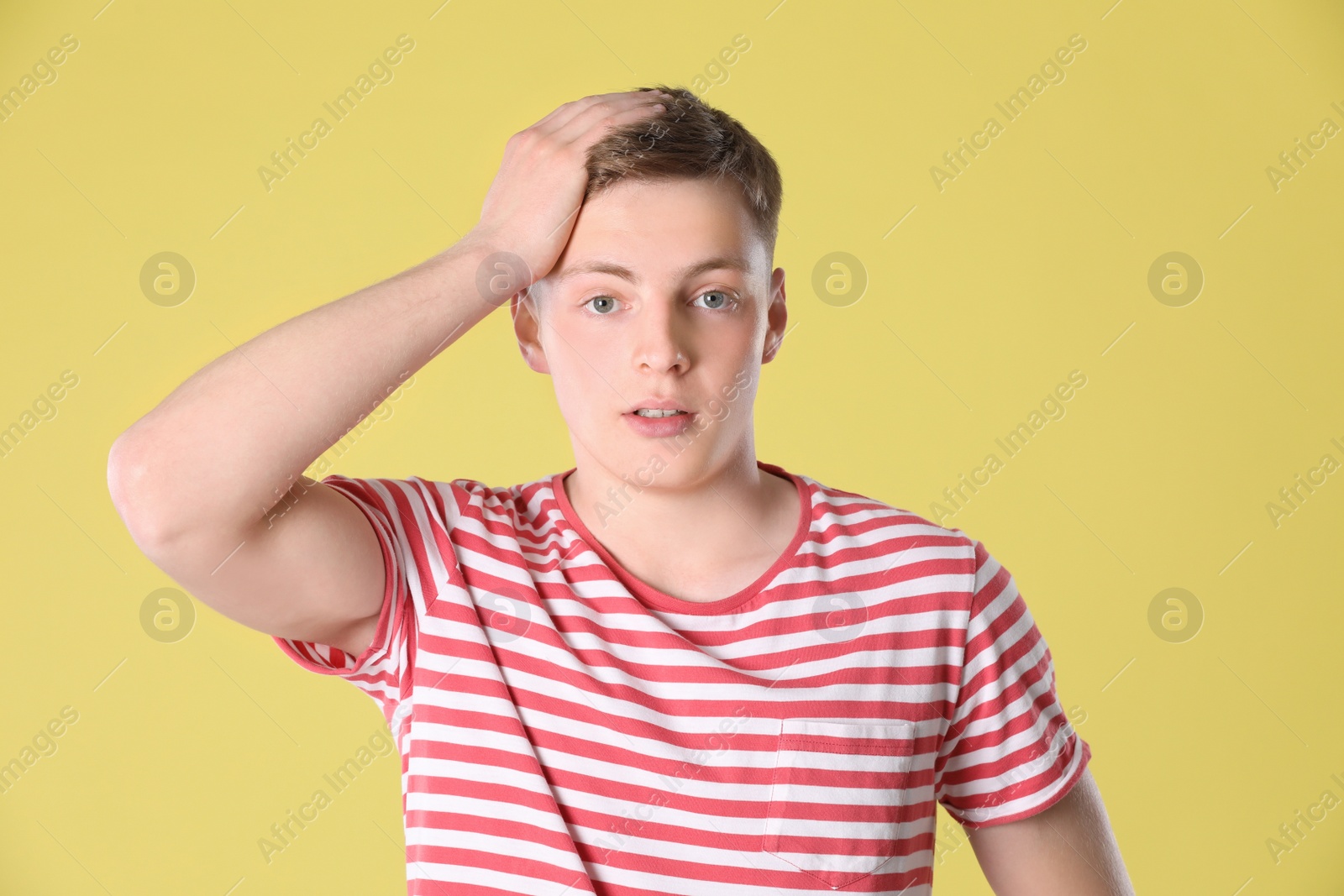 Photo of Portrait of emotional teenage boy on yellow background