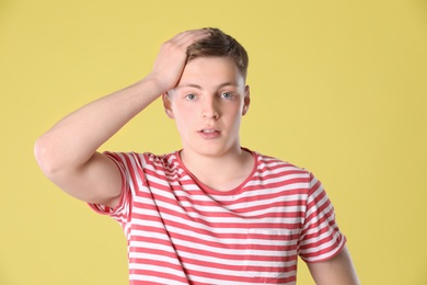 Photo of Portrait of emotional teenage boy on yellow background