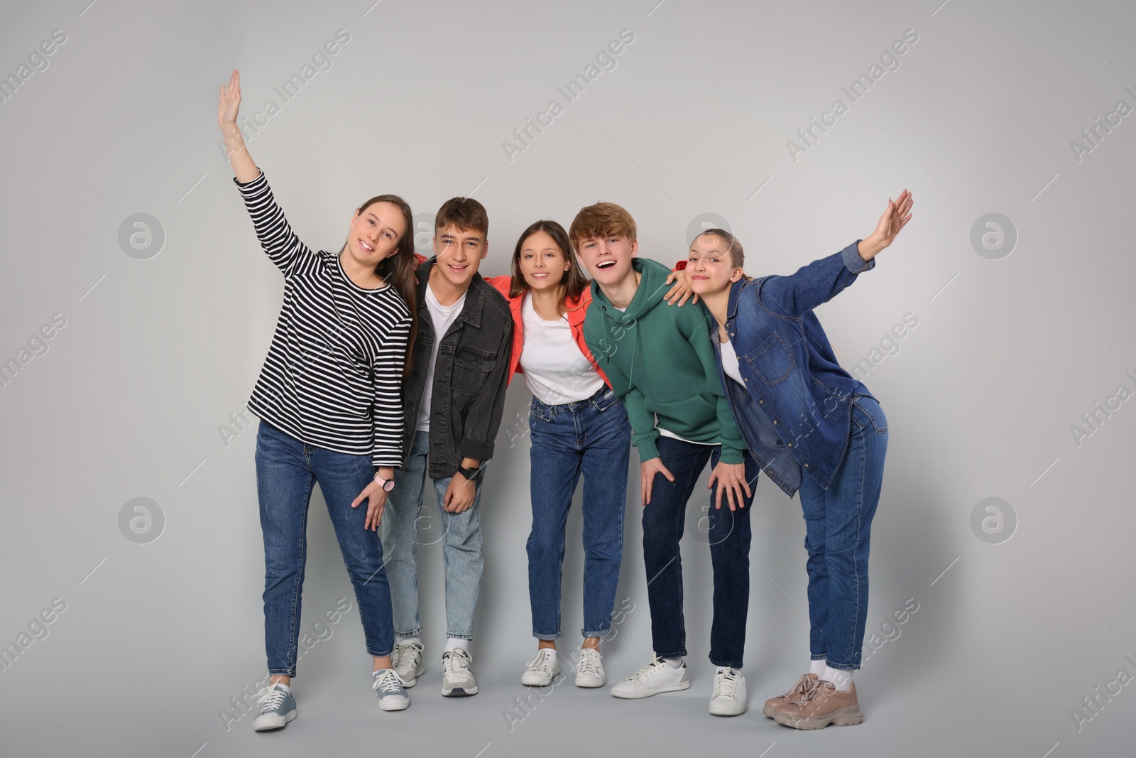 Photo of Group of happy teenagers on light grey background