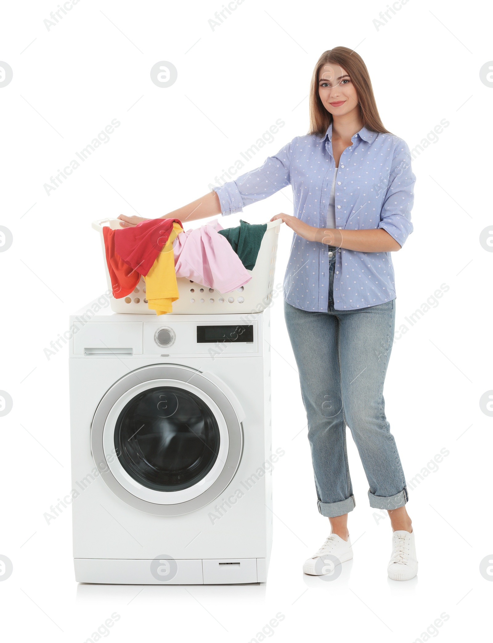 Photo of Young woman holding basket with dirty laundry near washing machine on white background