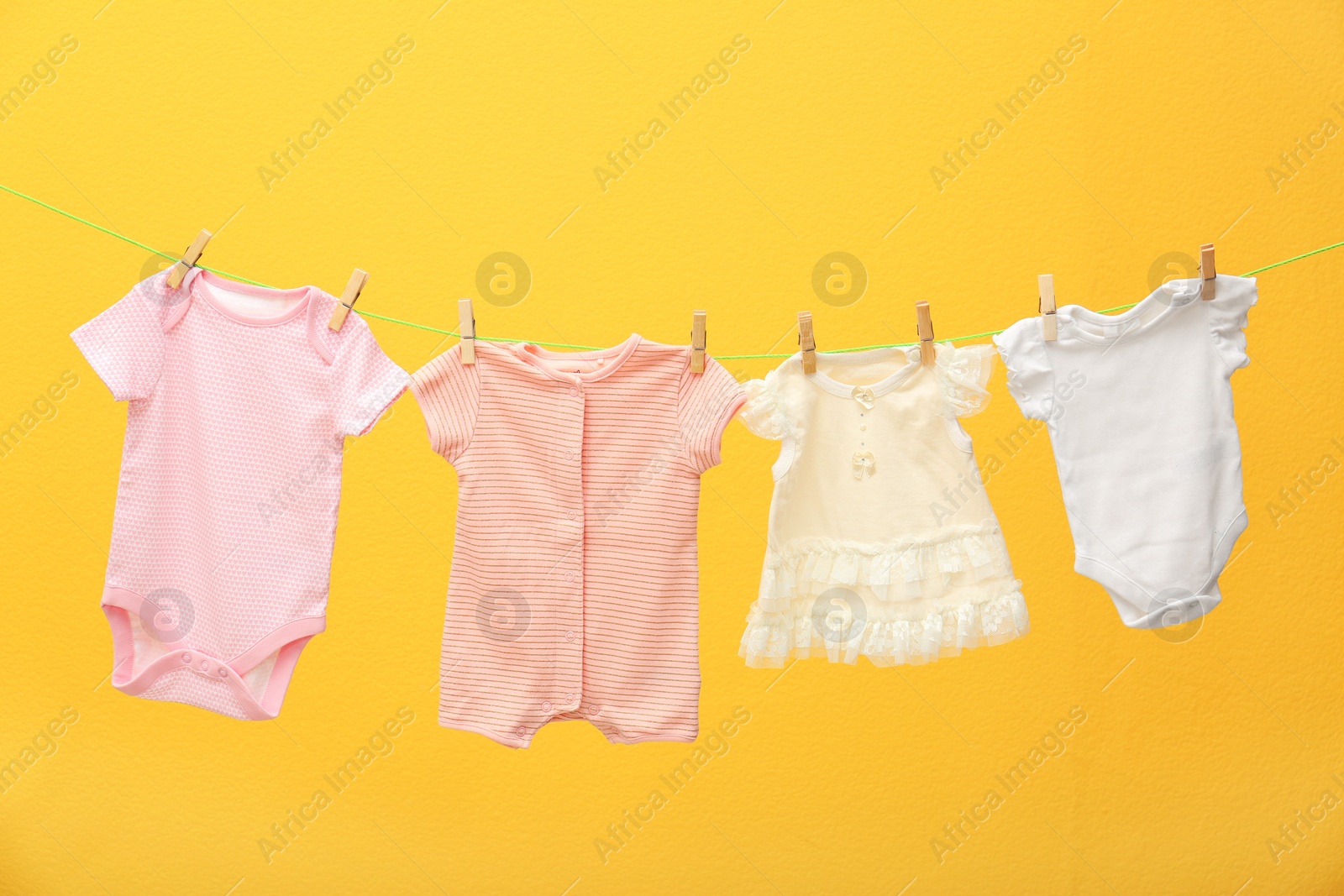 Photo of Children's clothes on laundry line against color background