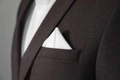 Photo of Man with handkerchief in breast pocket of his suit on light grey background, closeup