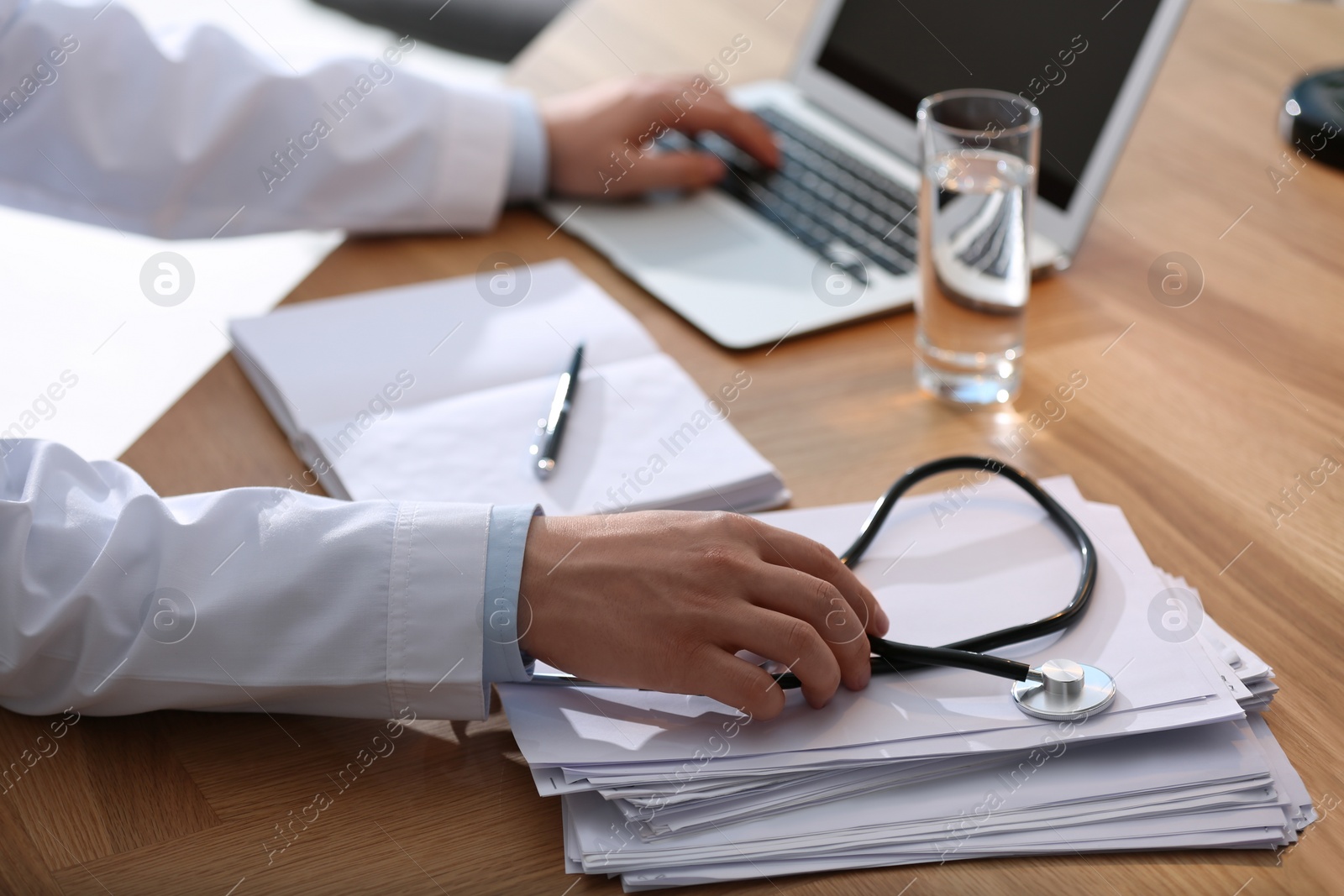 Photo of Professional doctor working on laptop in office, closeup