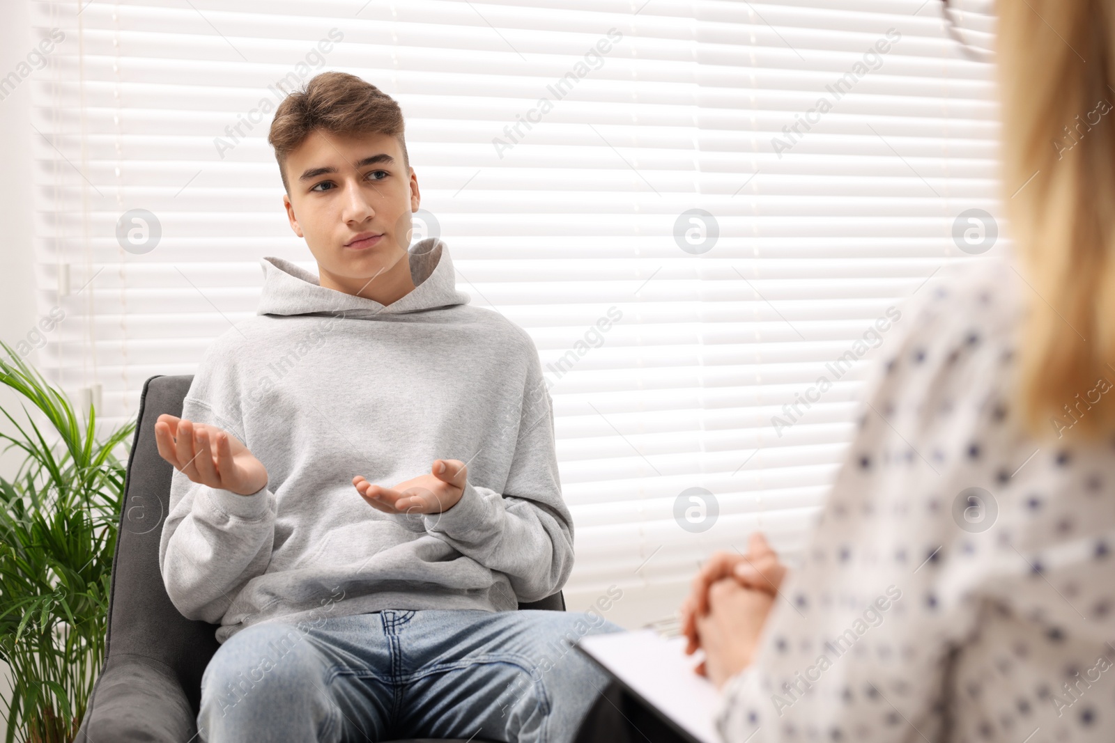 Photo of Psychologist working with teenage boy in office