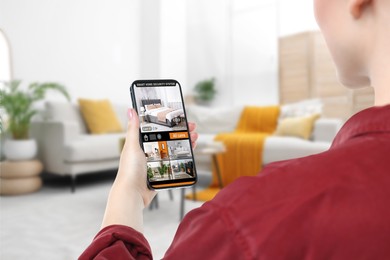 Woman using smart home security system on mobile phone indoors, closeup. Device showing different rooms through cameras