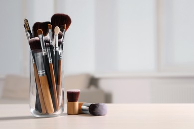 Photo of Set of professional brushes on wooden table indoors, space for text