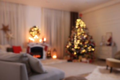 Blurred view of festively decorated room with Christmas tree near fireplace