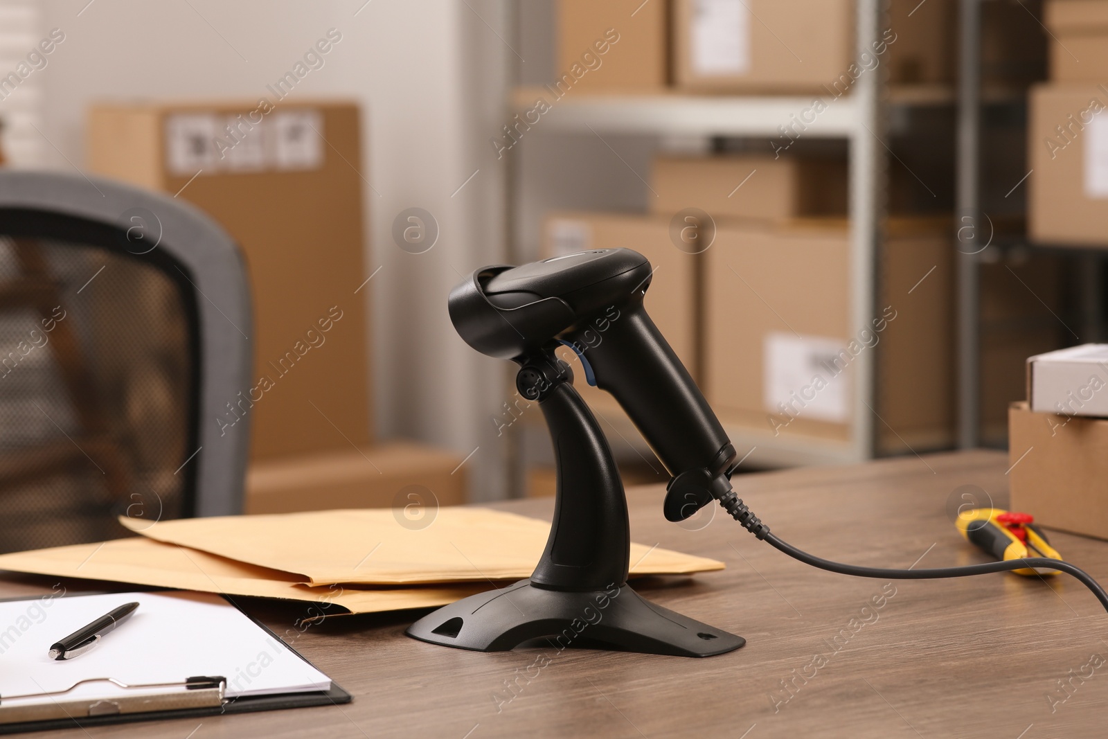 Photo of Black modern barcode scanner on wooden table in office. Online store