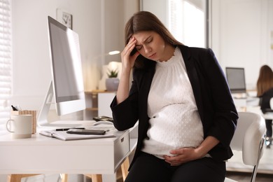 Photo of Tired pregnant woman working at home. Maternity leave