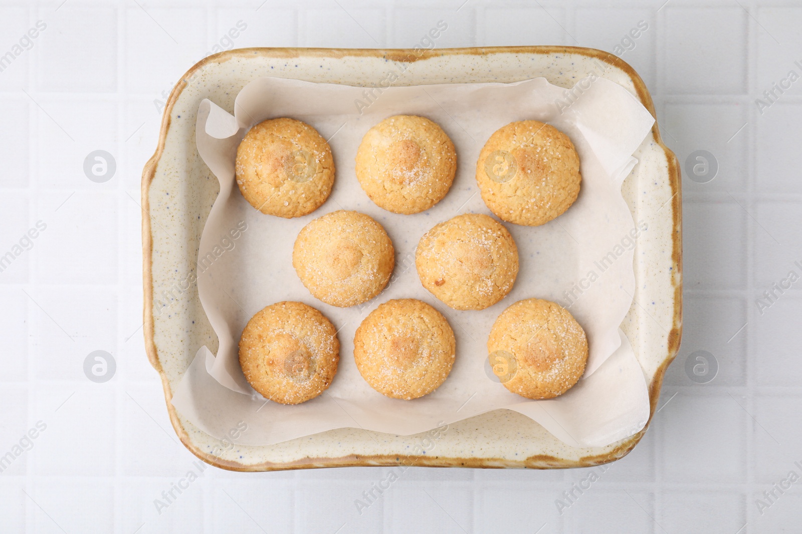 Photo of Tasty sweet sugar cookies in baking dish on white tiled table, top view