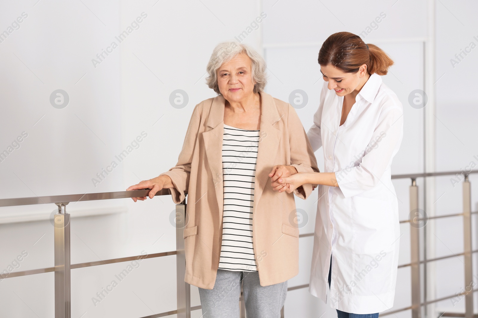 Photo of Elderly woman with caregiver indoors. Space for text