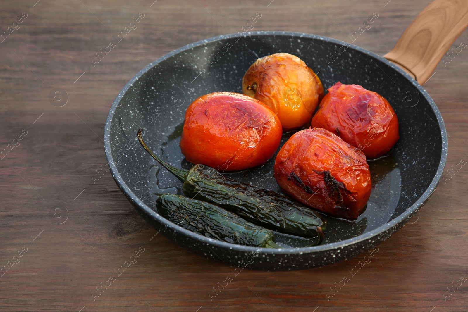 Photo of Frying pan with ingredients for salsa sauce on wooden table