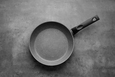 New non-stick frying pan on grey table, top view